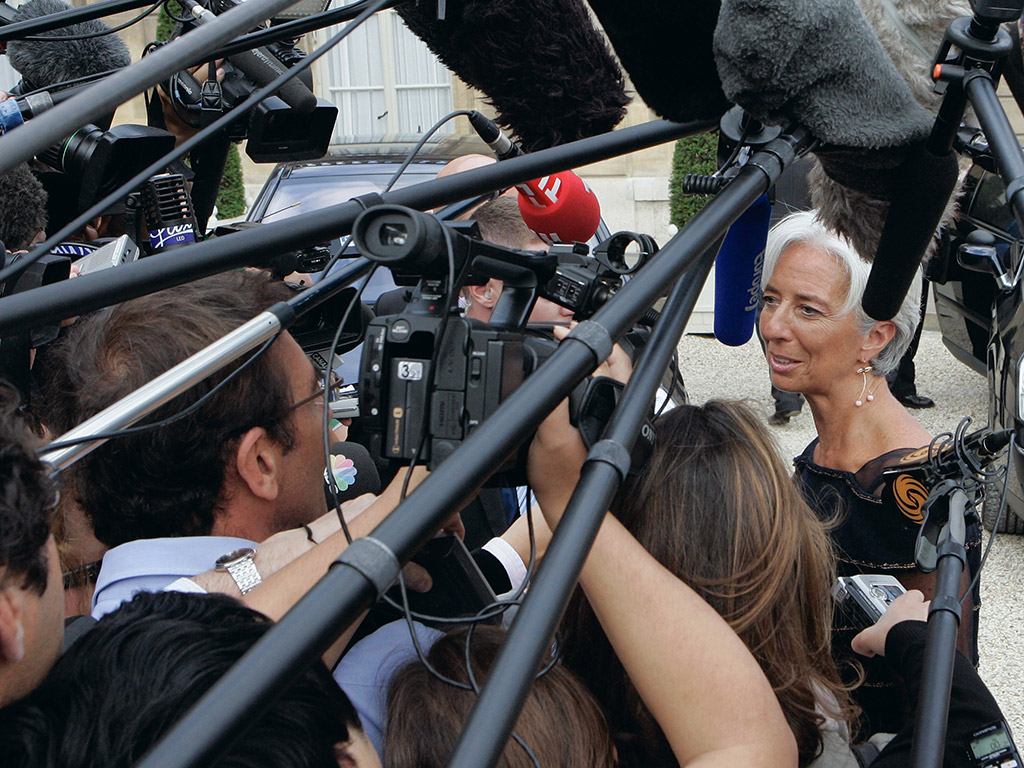 Christine Lagarde is surrounded by the media as she leaves a weekly cabinet meeting in France after being announced as the new managing director of the IMF