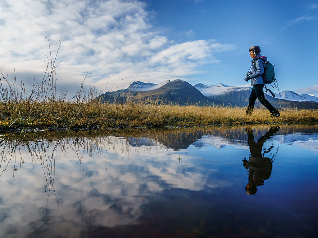 A woman hiking beside one of Iceland’s iconic lakes. Hiking, sailing and other activities have seen tourism grow by 100 percent in the country since 2006