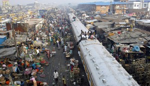 Commuters sit on top of a train at a rail track in the Oshodi district of Lagos. While Nigeria's population rapidly expands, housing has run short - presenting an opportunity for investors