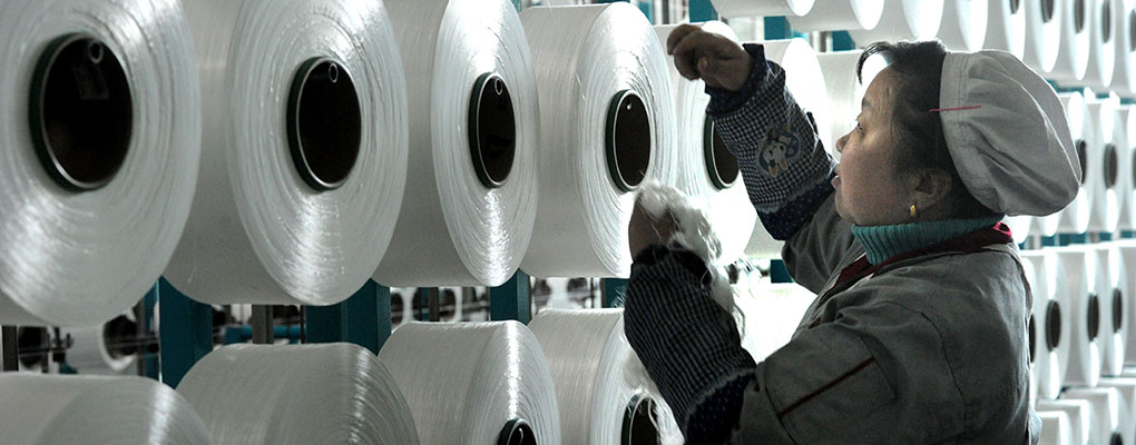 A Chinese worker checks a machine making blankets in east China's Zhejiang province. The country's exports were up 6.1 percent for the year compared with 2013, missing the government's trade growth target of 7.5 percent