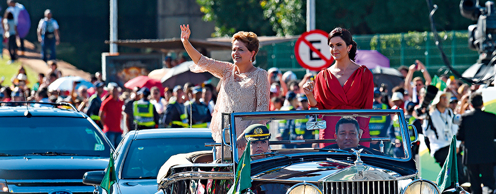 President Dilma Rousseff waves as she heads to the National Congress in Brasília to take the oath of office for her second term next to her daughter Paula