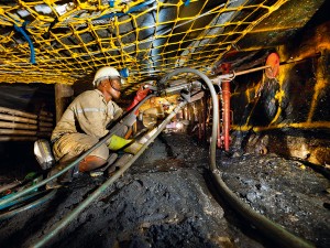 A miner drilling under strike nets in the Khomanani Mine, near Rustenburg, South Africa