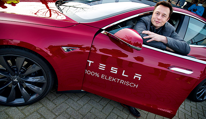Elon Musk, CEO of Tesla Motors, poses with a Tesla car in Amsterdam. The entrepreneur has offered his company's patents to rivals to encourage the adoption of electric cars