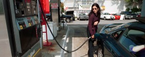 A woman fills up on petrol. Growth in the US economy and a pipeline shutdown has spurred on an increase in oil prices