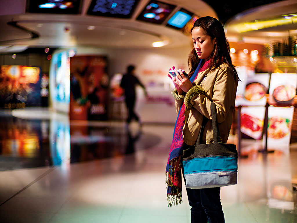 A woman stands outside a cinema complex in the US. More and more women are being represented in cinema, and female viewing figures are also increasing