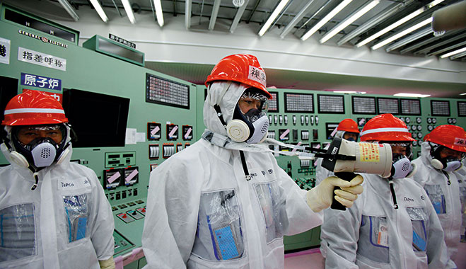 Staff at the Tokyo Electric Power Company measure radiation in the central operating control room of the reactors at the Fukushima Daiichi power plant, Okuma, Japan