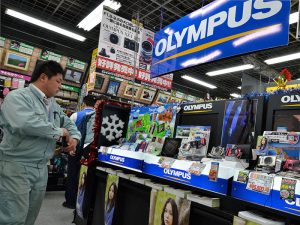 Olympus cameras on sale in Tokyo, Japan. Six former Olympus executives have been collectively charged with $520m worth of damages related to a scandal that came to light in 2011